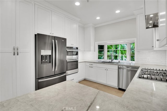 kitchen featuring white cabinets, appliances with stainless steel finishes, tasteful backsplash, sink, and light stone counters