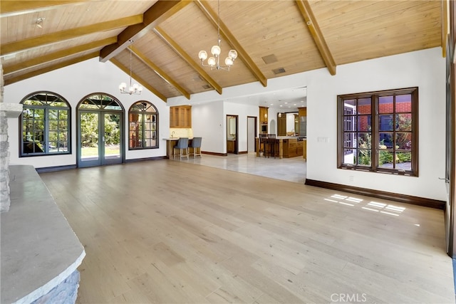 unfurnished living room with wooden ceiling, light hardwood / wood-style floors, beam ceiling, and a notable chandelier