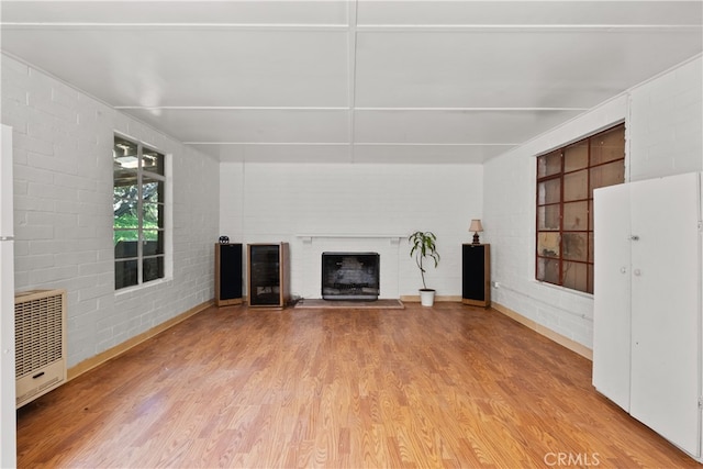 unfurnished living room with hardwood / wood-style floors and heating unit