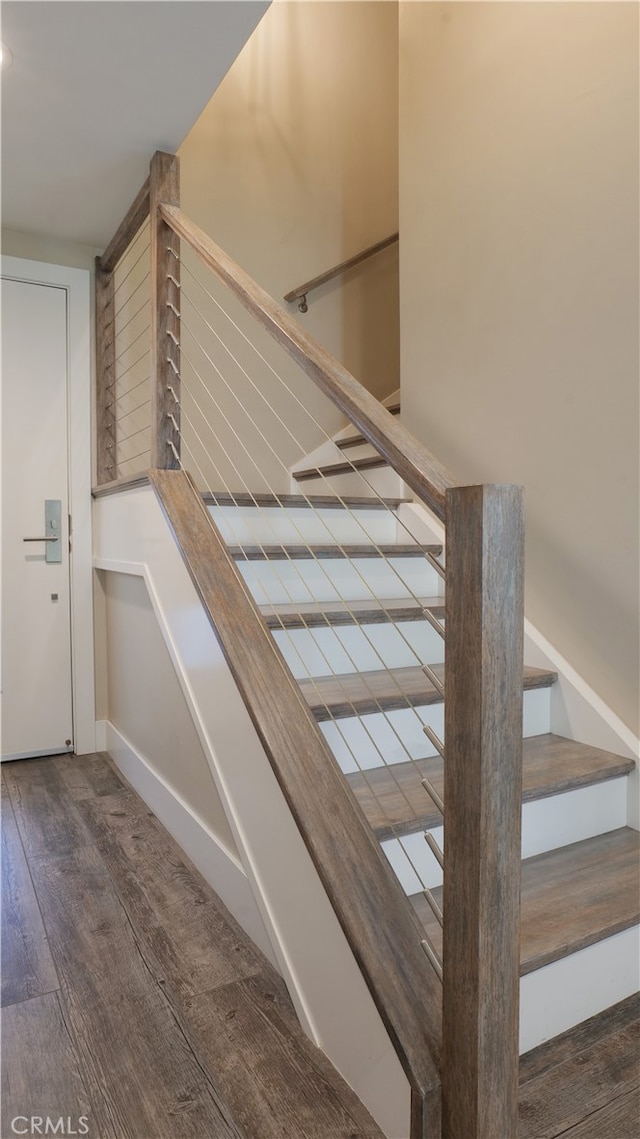 stairway with baseboards and wood finished floors