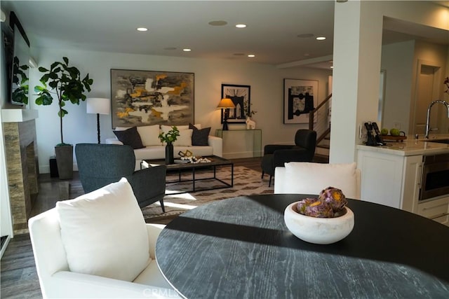 dining space featuring stairs, a fireplace, wood finished floors, and recessed lighting