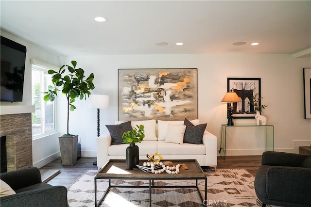 living area with recessed lighting, wood finished floors, and a high end fireplace