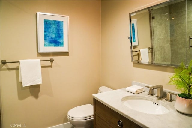 bathroom with toilet, baseboards, tiled shower, and vanity