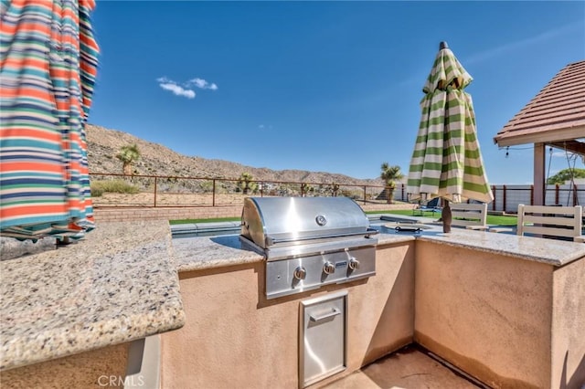 view of patio / terrace with a mountain view, an outdoor kitchen, and grilling area