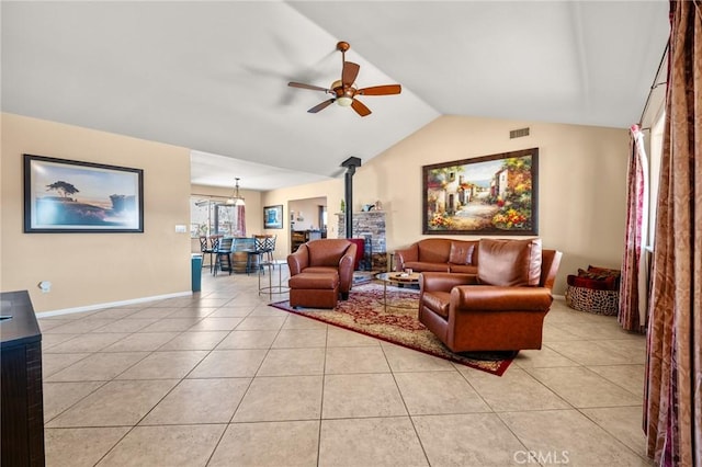 tiled living room with a wood stove, ceiling fan, and lofted ceiling