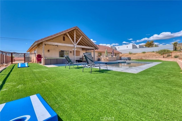 rear view of property featuring a yard, a fenced in pool, and a patio