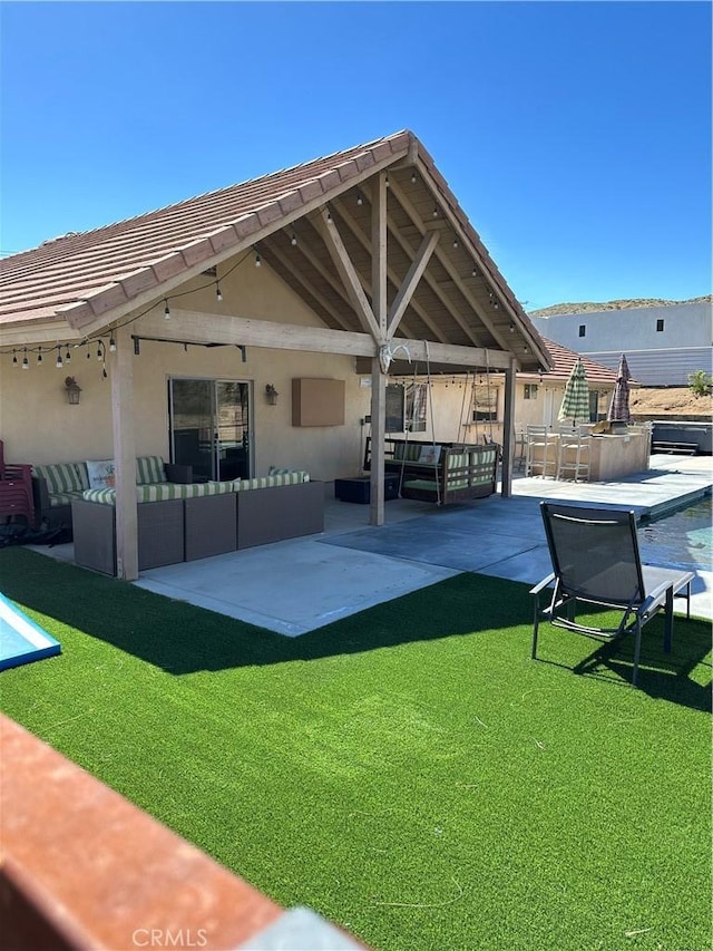 rear view of house featuring a lawn, a patio area, an outdoor living space, and a swimming pool