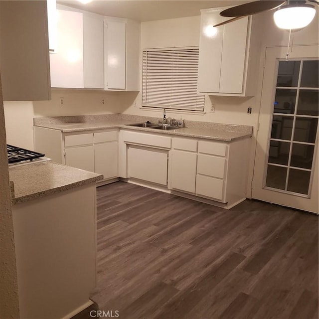 kitchen with white cabinets, sink, white gas cooktop, and dark wood-type flooring