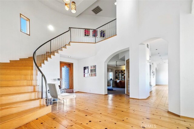 entryway with a high ceiling, hardwood / wood-style flooring, and ceiling fan