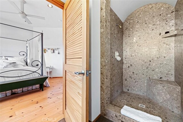 bathroom featuring ceiling fan, wood-type flooring, and tiled shower