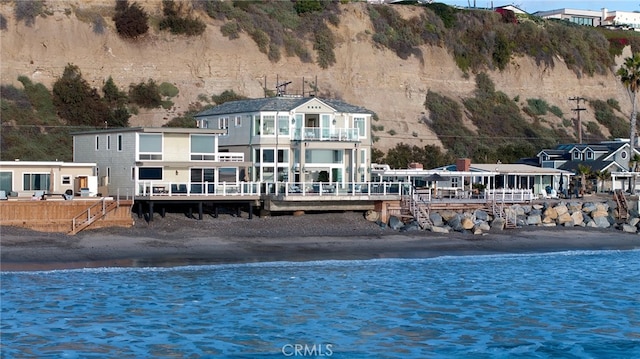 back of house featuring a view of the beach and a water view