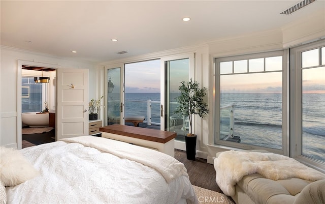 bedroom with access to exterior, multiple windows, dark hardwood / wood-style floors, and a water view