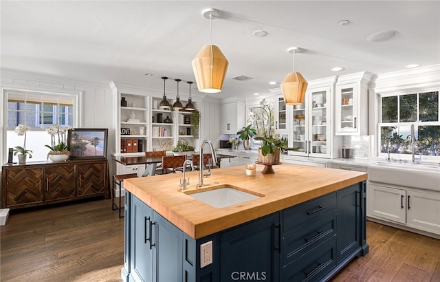 kitchen with white cabinets, hanging light fixtures, sink, and plenty of natural light