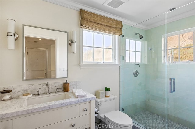 bathroom with crown molding, plenty of natural light, vanity, and toilet