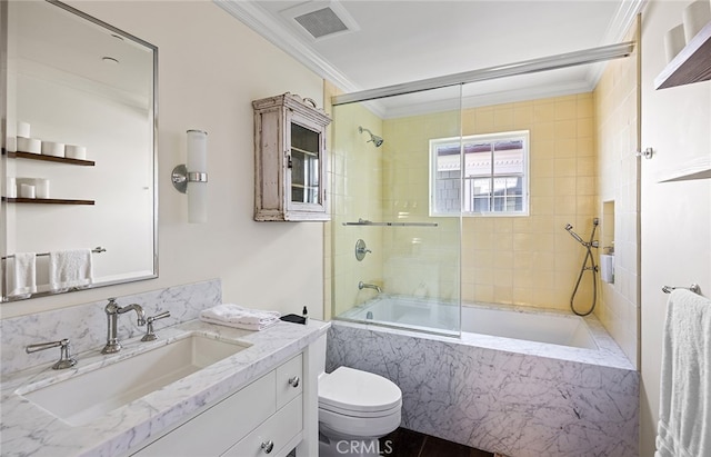 full bathroom featuring crown molding, bath / shower combo with glass door, toilet, and vanity