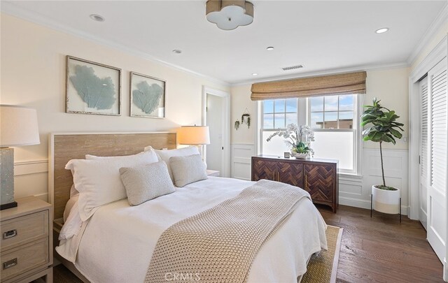 bedroom with ornamental molding and dark hardwood / wood-style floors