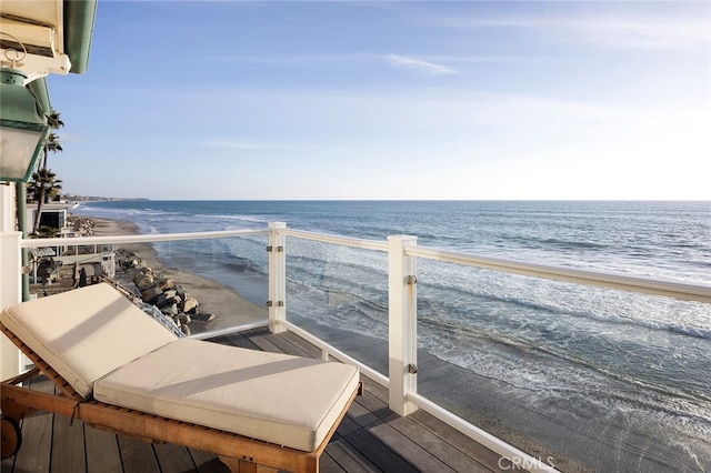 balcony with a water view and a beach view