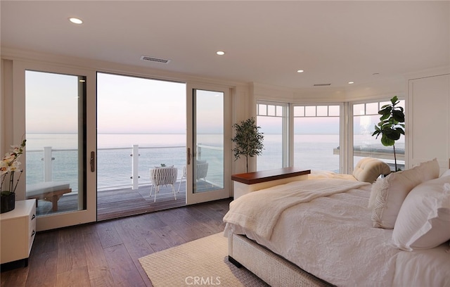 bedroom with french doors, dark wood-type flooring, access to exterior, and a water view