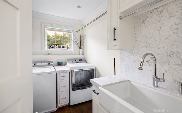 laundry room with independent washer and dryer, dark wood-type flooring, cabinets, ornamental molding, and sink