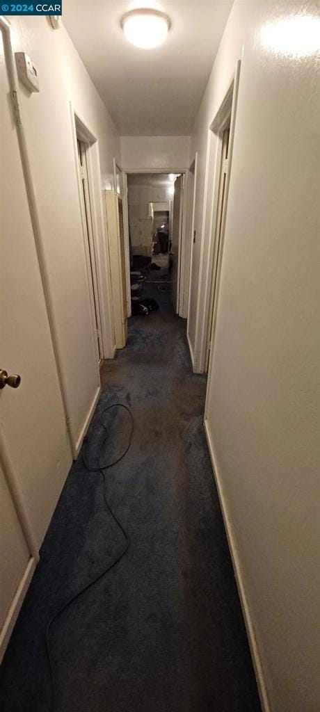 corridor with dark colored carpet