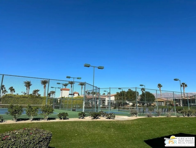 view of property's community featuring basketball hoop and a yard