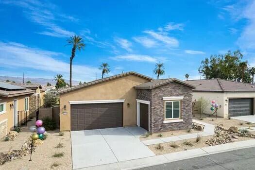 single story home featuring solar panels and a garage