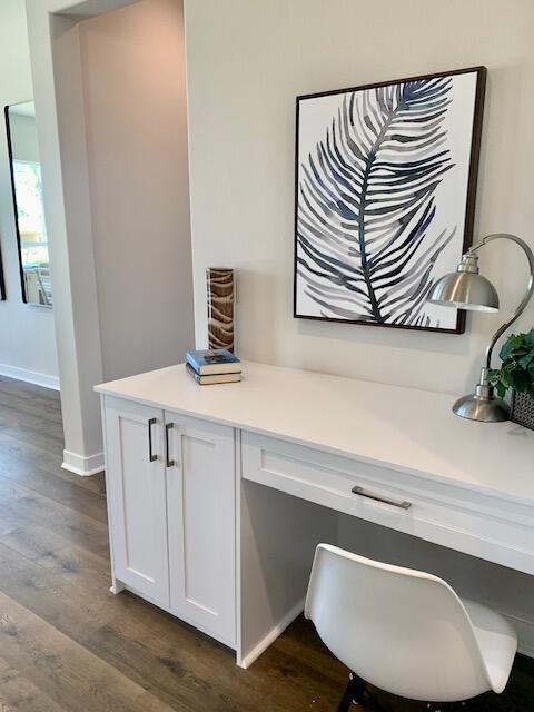 home office featuring dark hardwood / wood-style floors and built in desk