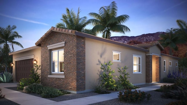 view of front of home with a garage and a mountain view