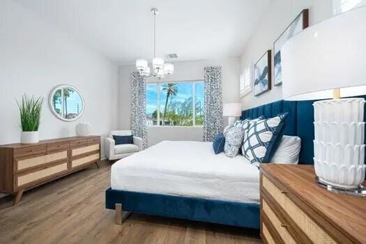 bedroom with an inviting chandelier and wood-type flooring