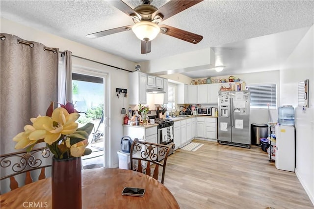 kitchen featuring white cabinets, appliances with stainless steel finishes, light hardwood / wood-style floors, and sink