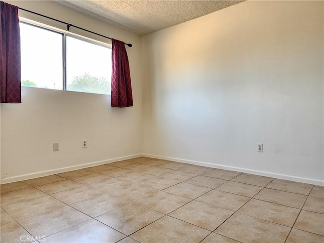 unfurnished room with light tile patterned floors and a textured ceiling