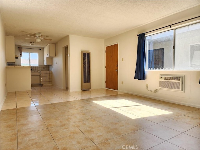 tiled empty room with ceiling fan, an AC wall unit, and a textured ceiling