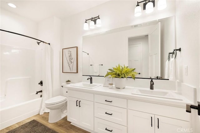 full bathroom with shower / bath combo with shower curtain, vanity, wood-type flooring, and toilet