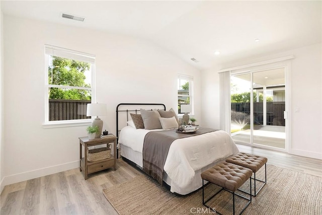 bedroom with access to exterior, light hardwood / wood-style floors, and lofted ceiling