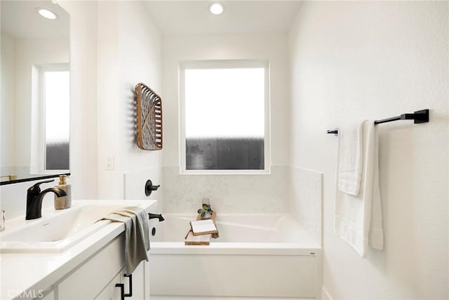 bathroom featuring vanity and a bath