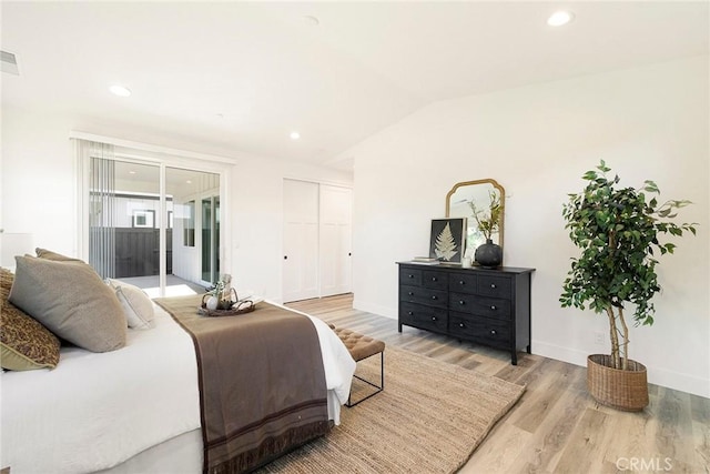 bedroom featuring access to outside, a closet, wood-type flooring, and lofted ceiling