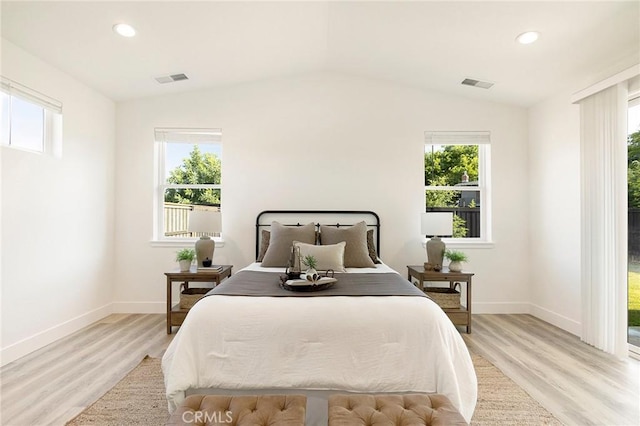 bedroom featuring light hardwood / wood-style flooring, multiple windows, and lofted ceiling