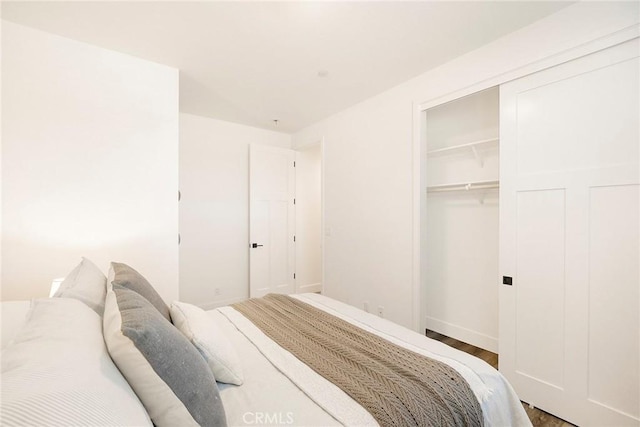 bedroom with wood-type flooring and a closet