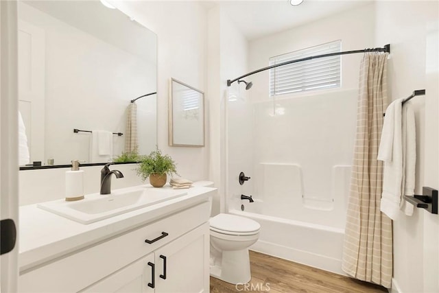 full bathroom featuring hardwood / wood-style floors, vanity, shower / bath combination with curtain, and toilet