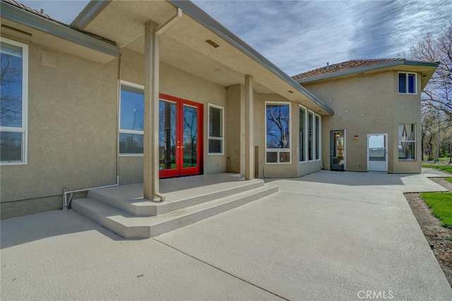 property entrance featuring french doors and a patio area