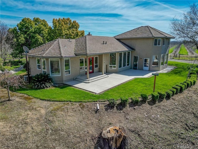 back of house featuring a yard and a patio