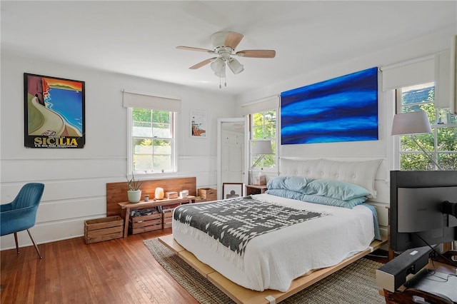 bedroom featuring multiple windows, hardwood / wood-style flooring, and ceiling fan