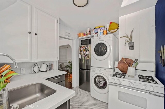 laundry room with sink, light tile patterned floors, and stacked washer and clothes dryer