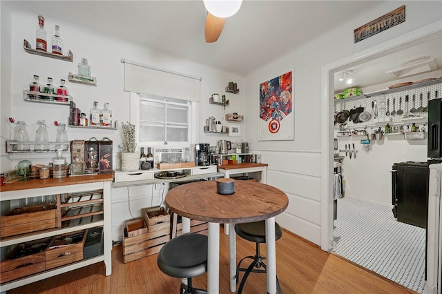 dining space with ceiling fan and light hardwood / wood-style flooring