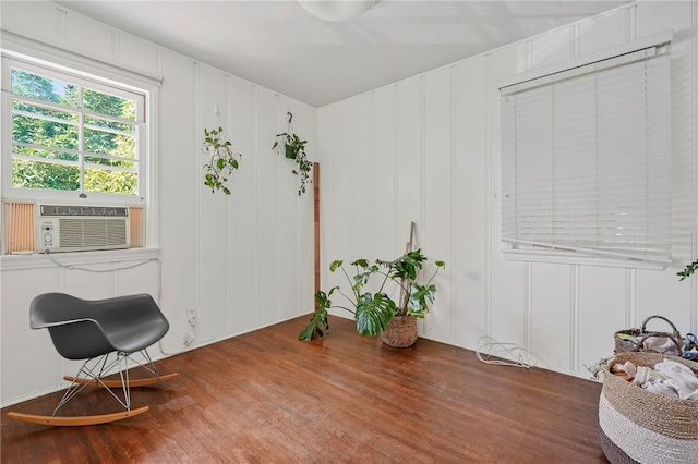 living area with cooling unit and hardwood / wood-style flooring