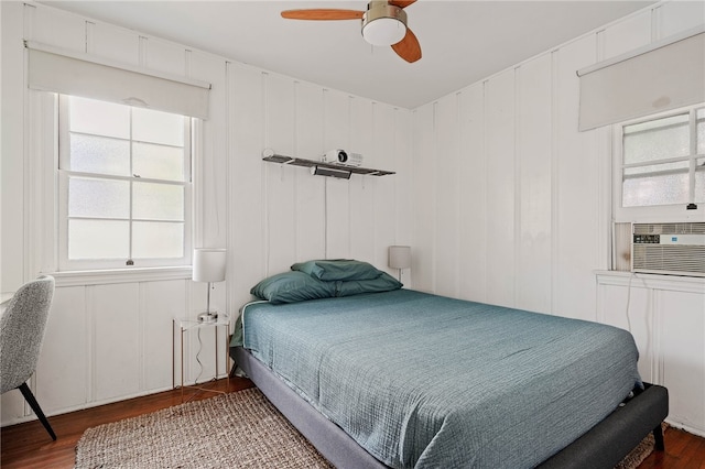 bedroom with cooling unit, ceiling fan, hardwood / wood-style flooring, and multiple windows