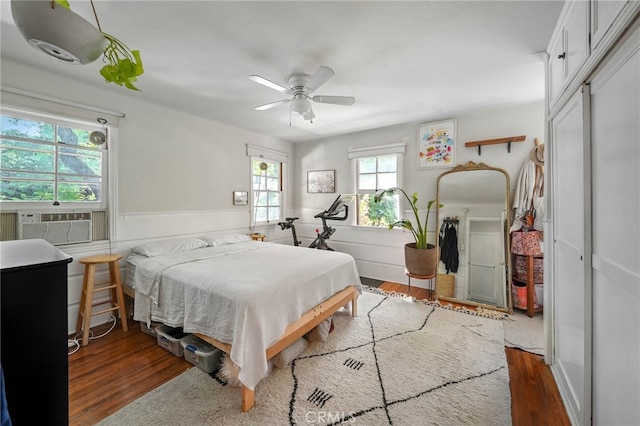 bedroom with a closet, ceiling fan, dark hardwood / wood-style floors, and cooling unit