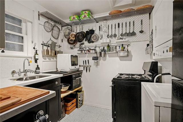 kitchen with stacked washer / dryer, sink, and range with gas cooktop