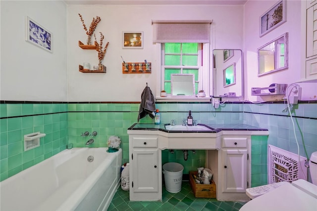 bathroom with vanity, tile walls, and a tub