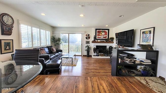 living room featuring hardwood / wood-style floors and a brick fireplace